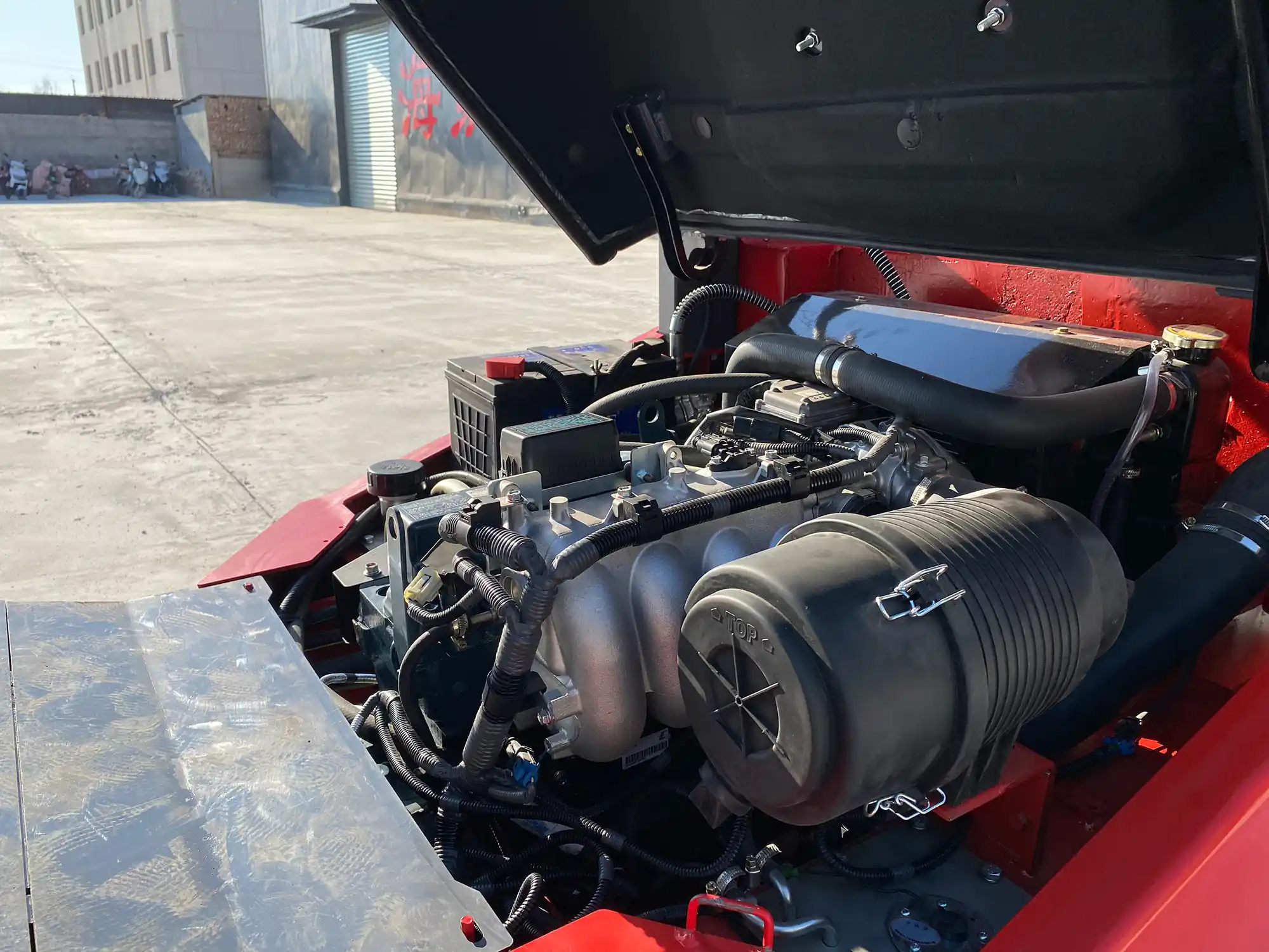 Close-up view of a DOGON diesel forklift engine compartment with open hood, showing the robust engine block and air filtration system.